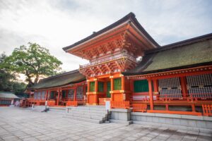 A bright vermilion gate and main hall of Usa Hachiman Shrine in Kyushu, Japan. The shrine is renowned for its pivotal oracles during the Dōkyō incident, affirming the unbroken imperial line.