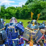 A group of samurai in traditional Japanese armor stands side by side on a green field, recalling the Sengoku period and the values of honor, loyalty, and duty.